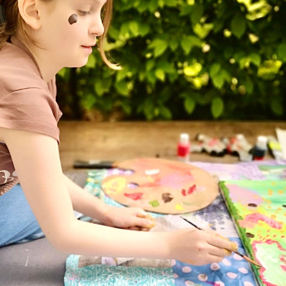 Kind malt mit Freude auf Leinwand in einem individuellen Malkurs